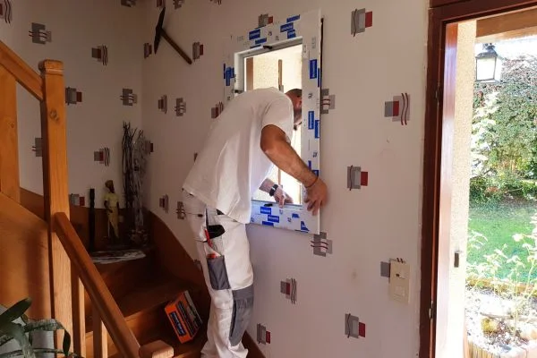 Artisan qui pose une fenêtre en PVC